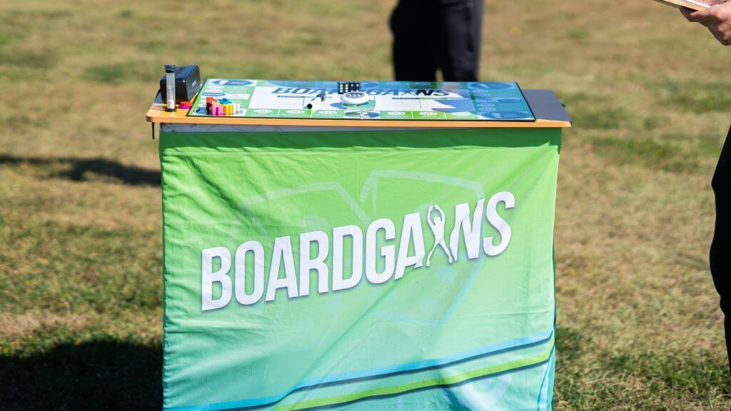 FX Productions Canada A table covered with a green cloth displaying the word "BOARDGAINS" and a game board on top, set outdoors on grass—perfect for a creative Toronto Video Production shoot. Toronto Video Production Company