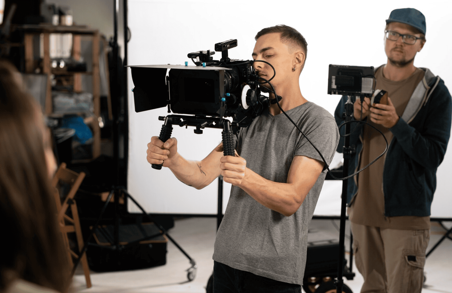 FX Productions Canada A person operates a professional video camera on set, while another stands behind holding audio equipment in a studio—capturing the behind-the-scenes energy of an FX Productions Canada shoot. Toronto Video Production Company