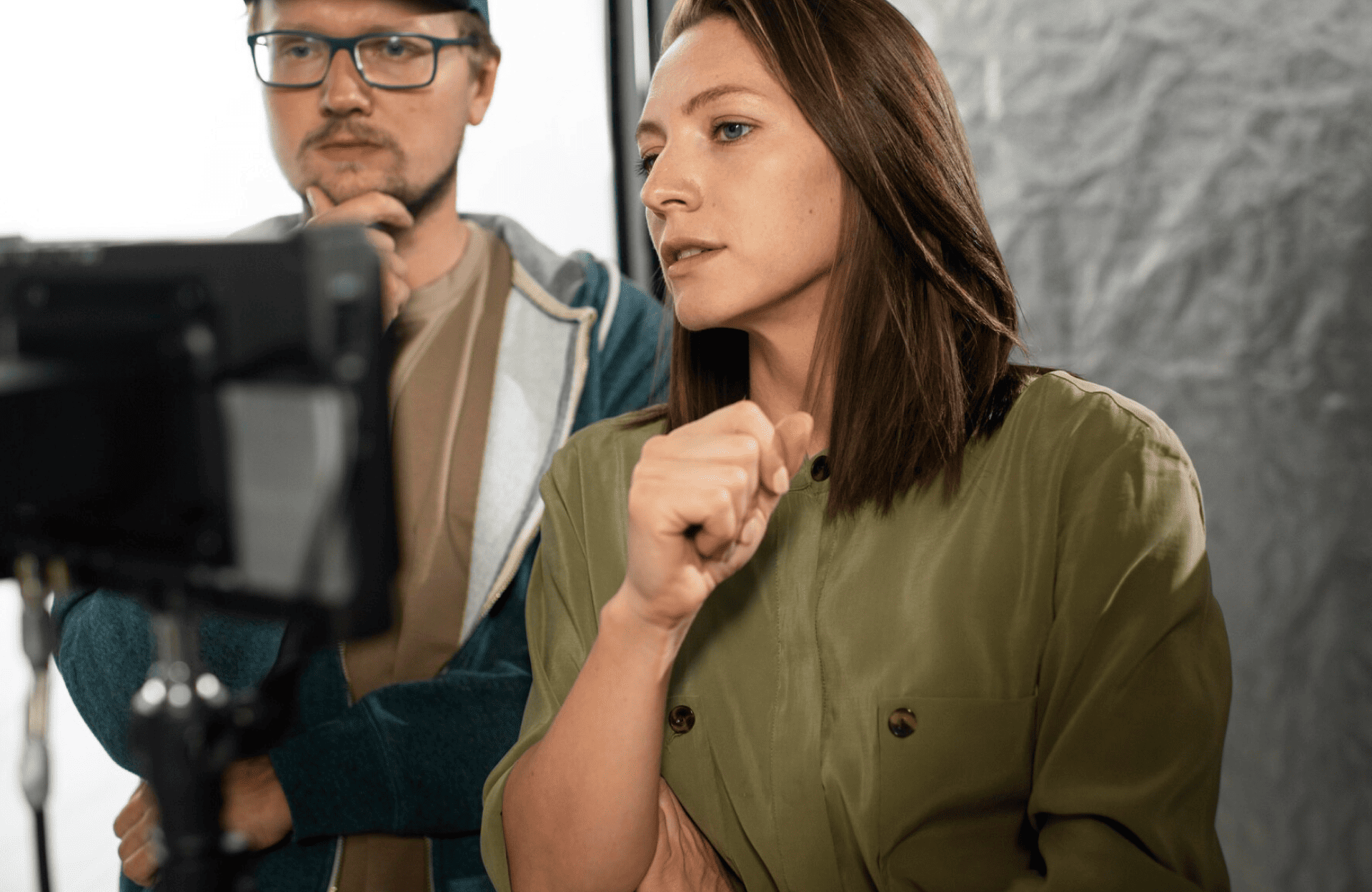 FX Productions Canada Two people stand closely together, looking intently at a screen. The woman in front is gesturing with her hand, while the man next to her—part of the Toronto Production Company—has his hand on his chin. Toronto Video Production Company