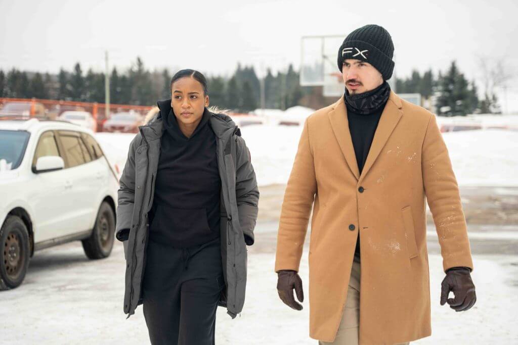 FX Productions Canada A woman and a man walk outdoors in winter clothing on a snowy day, with parked cars and trees in the background—captured by FX Productions Canada, a leading Toronto Video Production team. Toronto Video Production Company