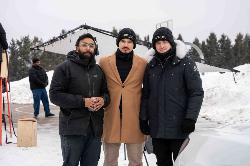 FX Productions Canada Three men in winter clothing stand outdoors on a snowy set with filming equipment and a plane in the background, showcasing the behind-the-scenes work of FX Productions Canada, a leading Toronto Video Production company. Toronto Video Production Company