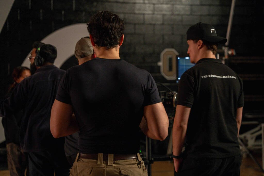 FX Productions Canada Several people stand together in a dimly lit room, some facing computer monitors, suggesting a film or video production setting at FX Productions Canada. Toronto Video Production Company