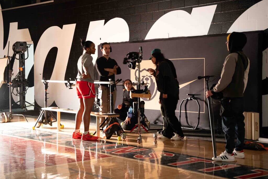 FX Productions Canada A Toronto Video Production crew sets up film equipment and cameras on a gym floor while one person in athletic wear stands nearby. Toronto Video Production Company