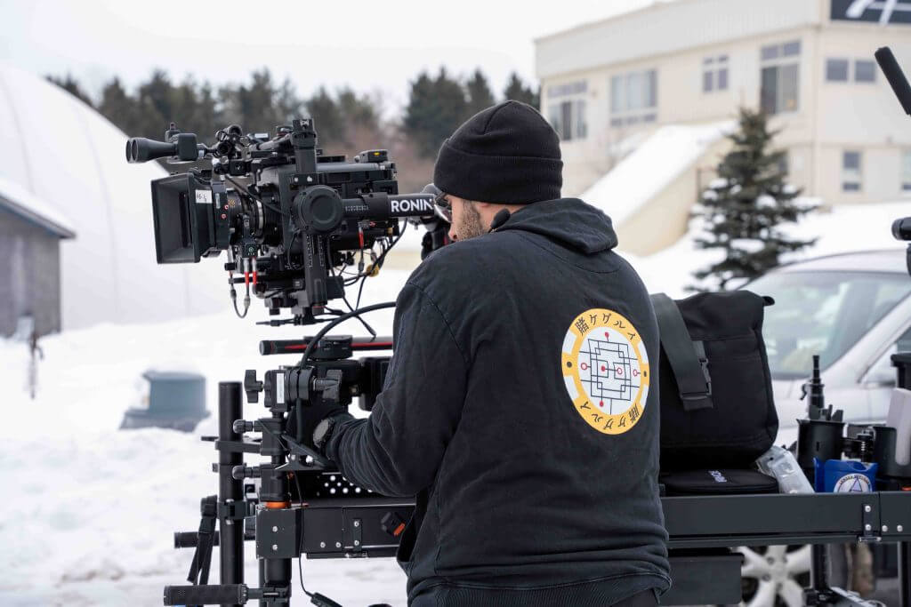 FX Productions Canada A person operates a professional video camera mounted on equipment outdoors in a snowy area, with buildings and trees behind—capturing stunning footage for FX Productions Canada, a leading Toronto Video Production company. Toronto Video Production Company