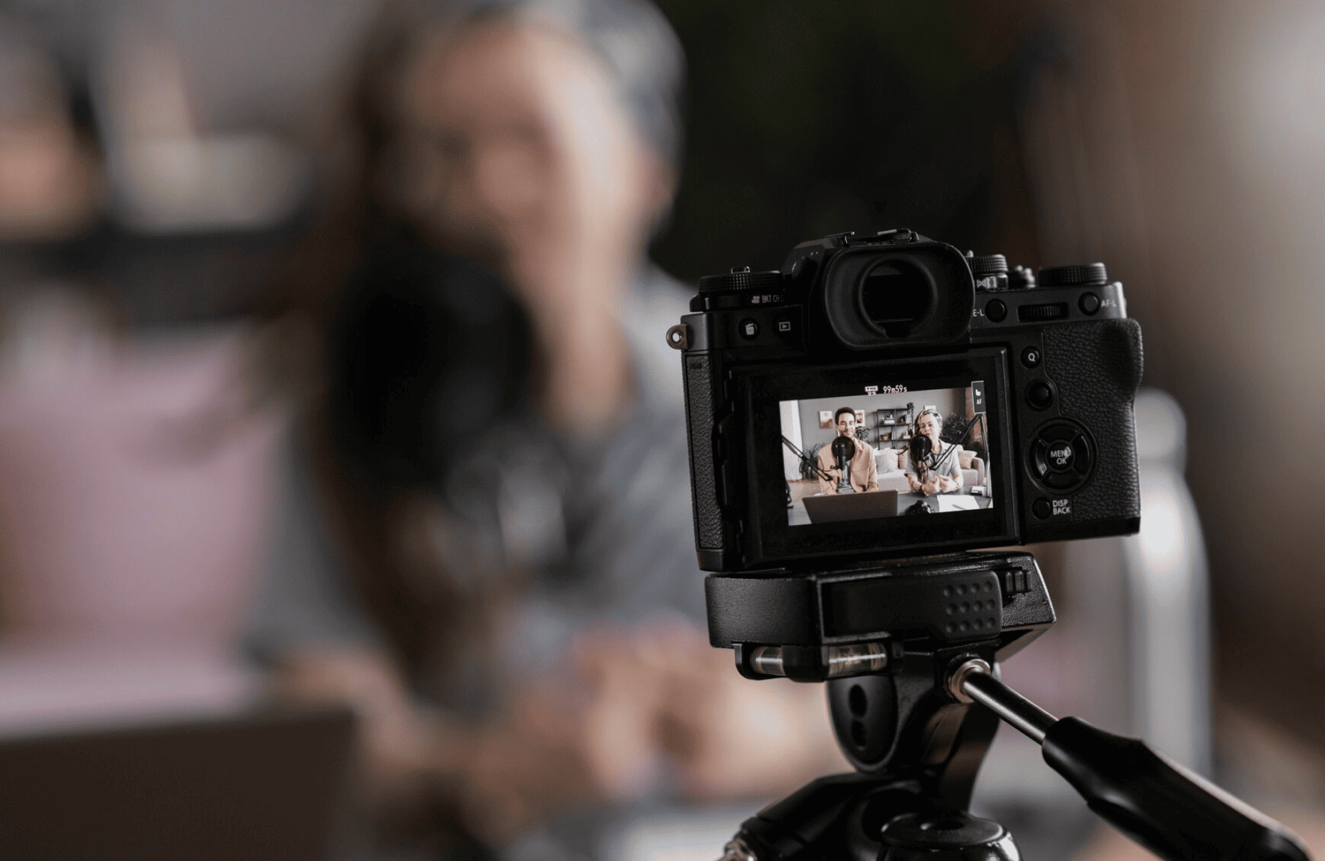 FX Productions Canada A digital camera on a tripod records a person sitting indoors; the subject appears on the camera’s display screen, but is blurred in the background. Toronto Video Production Company