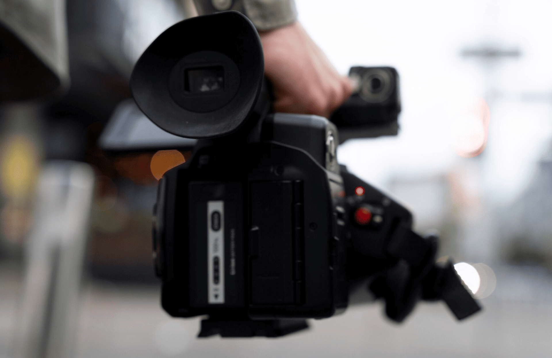 FX Productions Canada A person holds a professional video camera outdoors, with the focus on the camera and a blurred background. Toronto Video Production Company