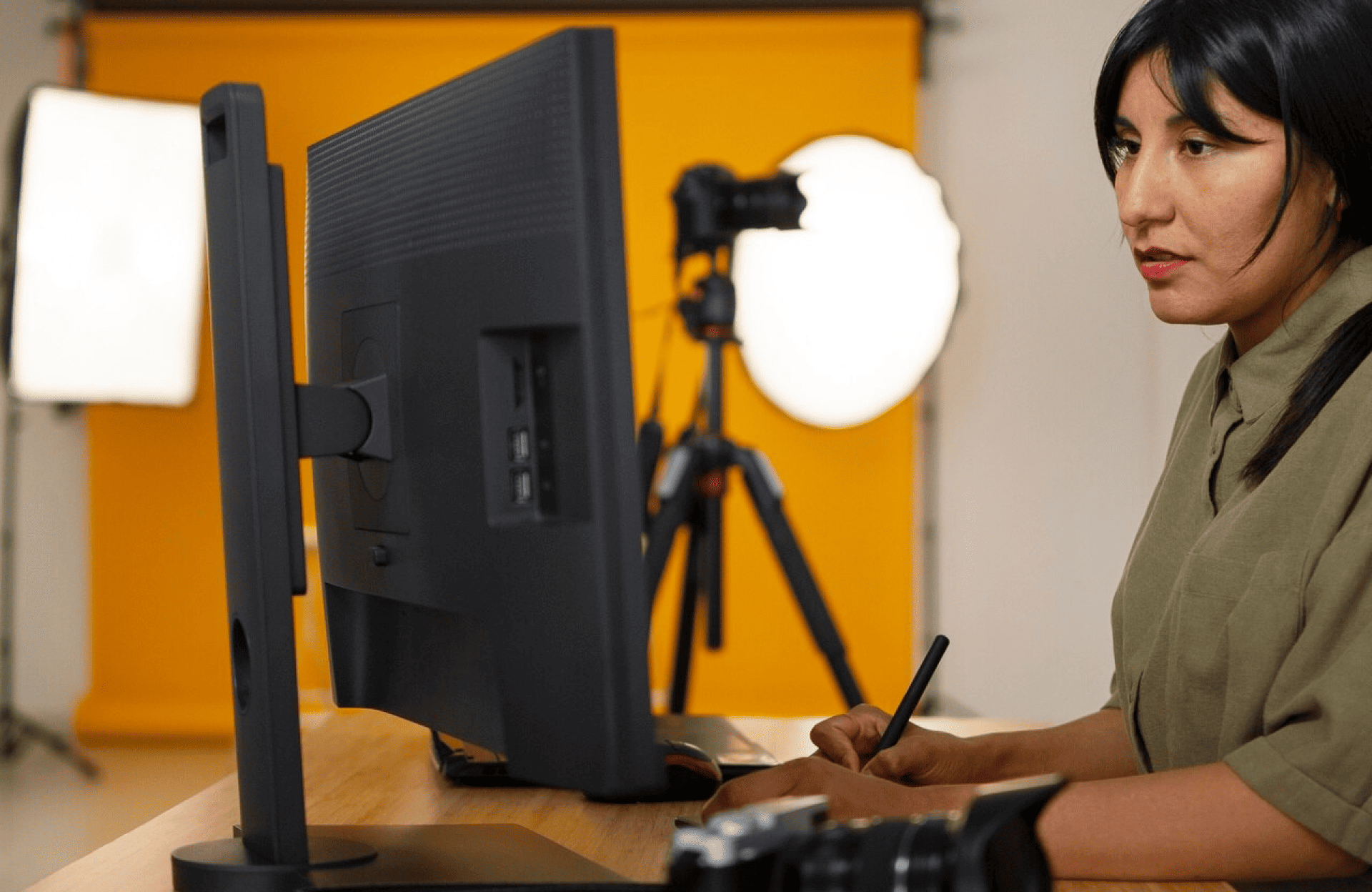 FX Productions Canada A person using a digital drawing tablet at a desk with a monitor, studio lights, a camera, and an orange backdrop in the background. Toronto Video Production Company