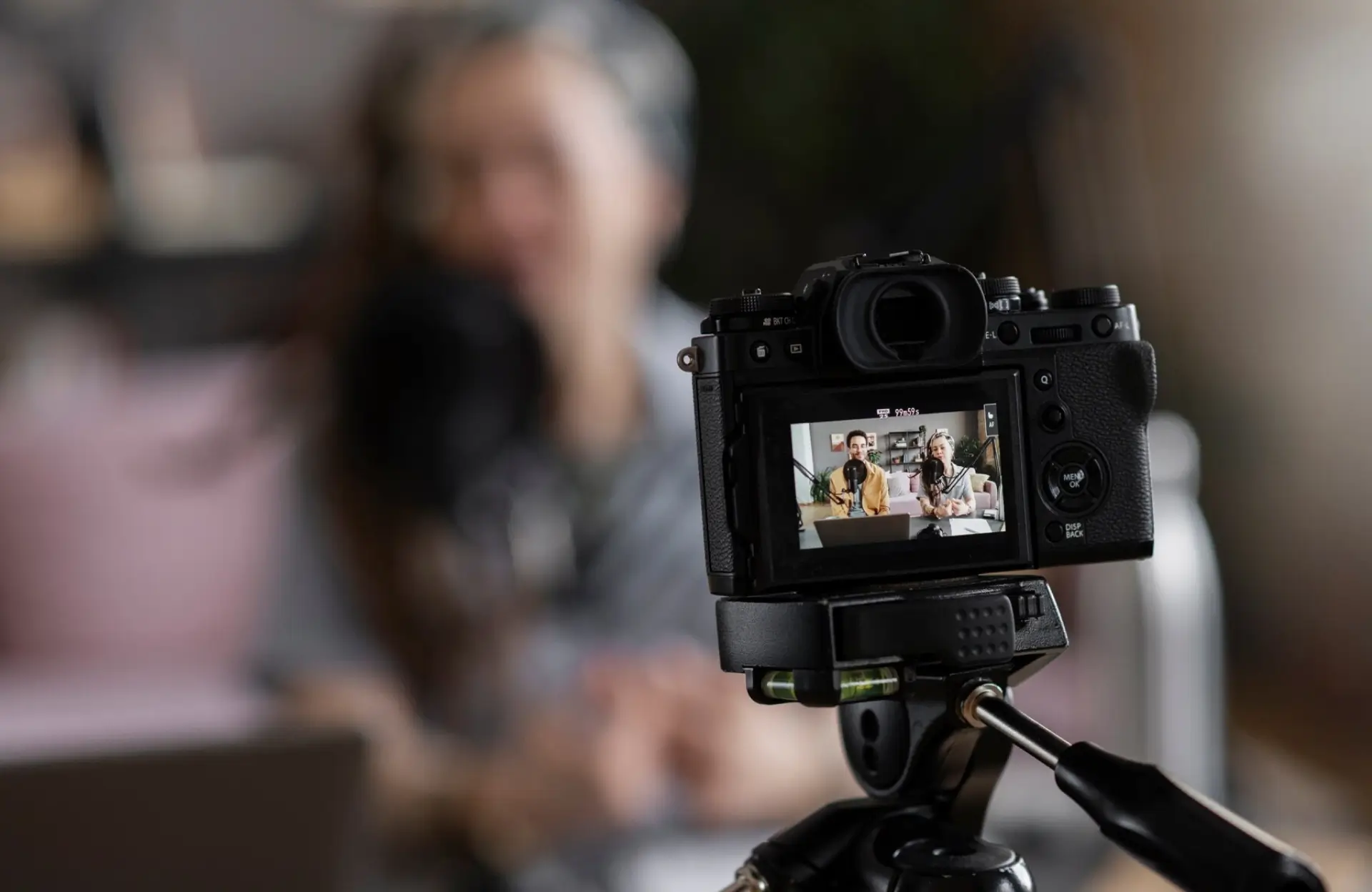 FX Productions Canada A digital camera on a tripod records a person sitting indoors; the camera’s screen shows the person in focus while the background is blurred. Toronto Video Production Company