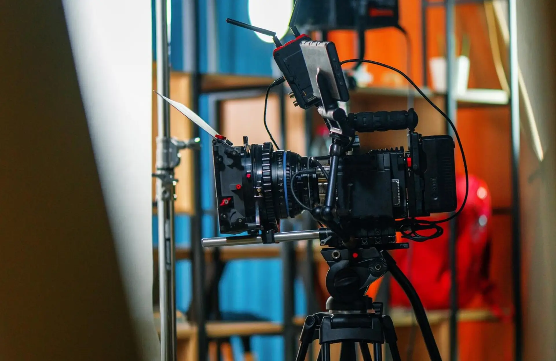 FX Productions Canada A professional video camera mounted on a tripod is positioned in a studio setting with shelves and various equipment in the background. Toronto Video Production Company