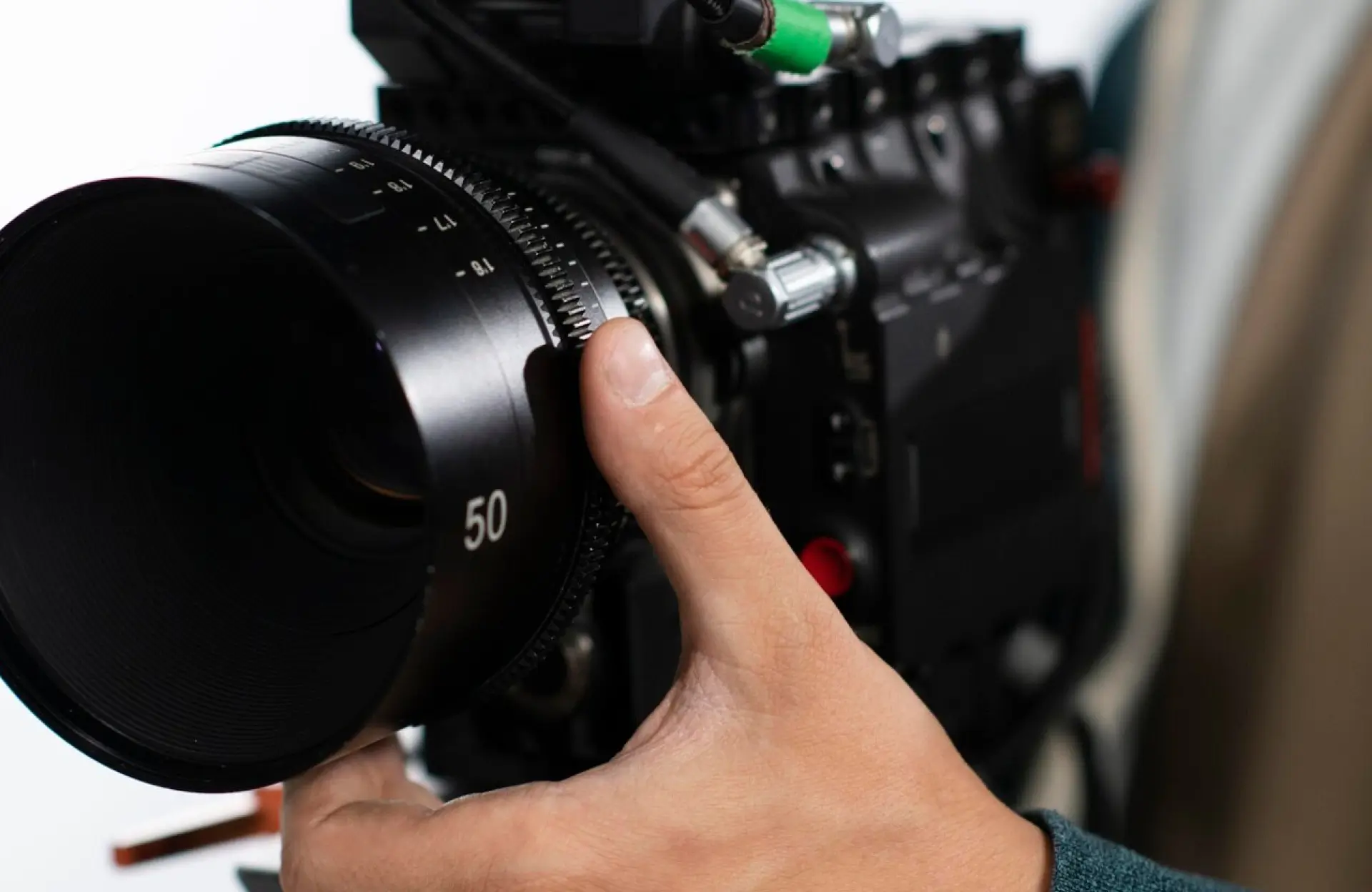 FX Productions Canada A person adjusts the focus ring of a professional video camera with a 50mm lens. Toronto Video Production Company