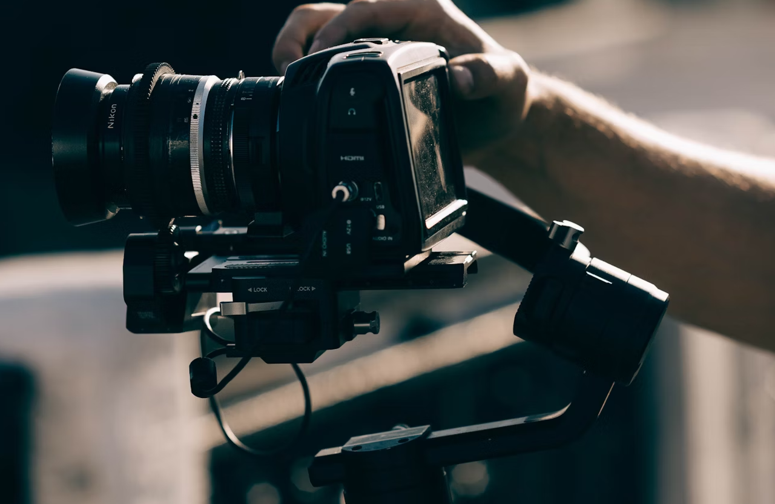 FX Productions Canada A person adjusts the settings on a professional video camera mounted on a stabilizing gimbal outdoors, capturing cinematic video production for FX Productions Canada. Toronto Video Production Company