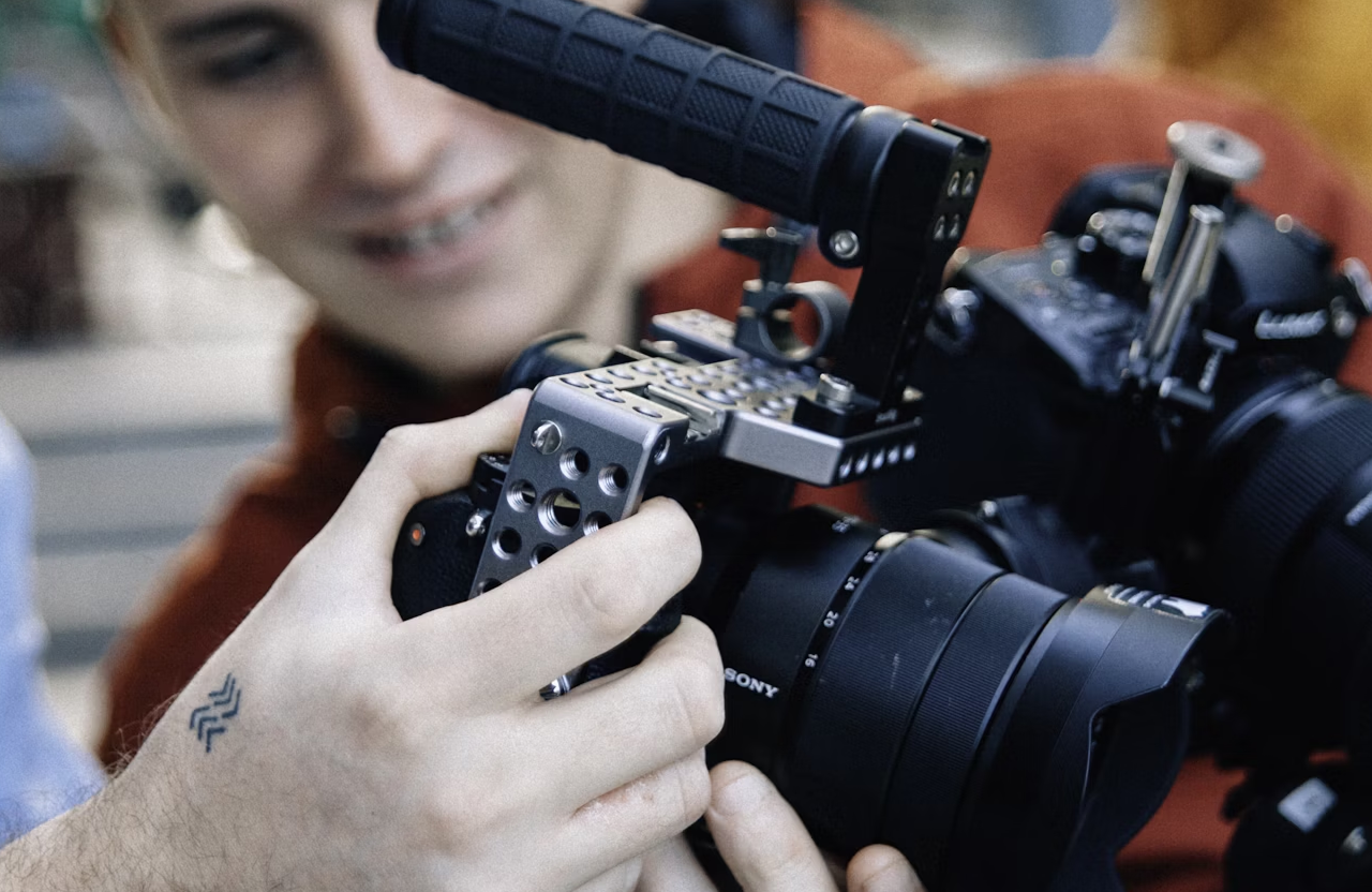 FX Productions Canada A person adjusts settings on a mounted Sony camera, focusing on video content strategy, while another looks on in the background. Toronto Video Production Company