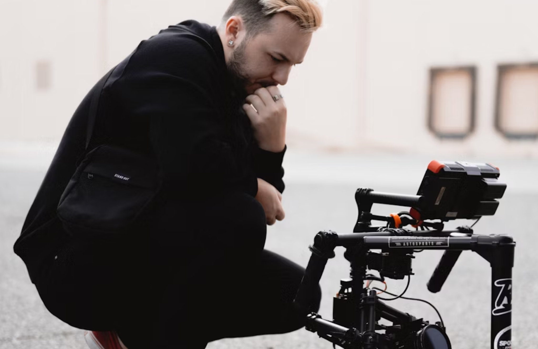 FX Productions Canada A person kneels outdoors, concentrating on a professional video camera rig with attached monitor positioned on the ground—a scene familiar to many video production companies Toronto relies on. Toronto Video Production Company