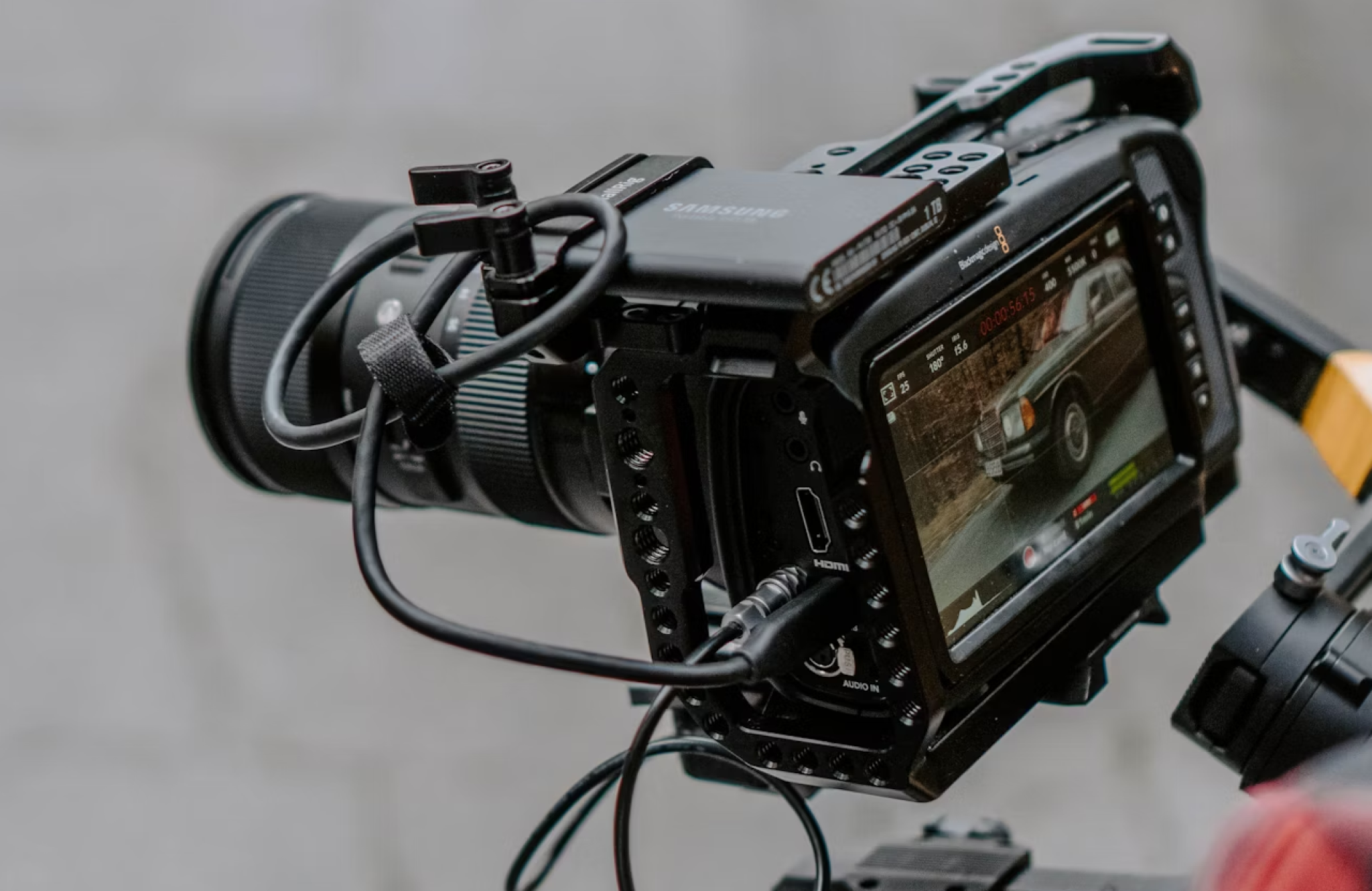 FX Productions Canada A professional video camera with a mounted monitor, commonly used by video production companies Toronto, displays a car on its screen; several cables are connected to the camera. Toronto Video Production Company