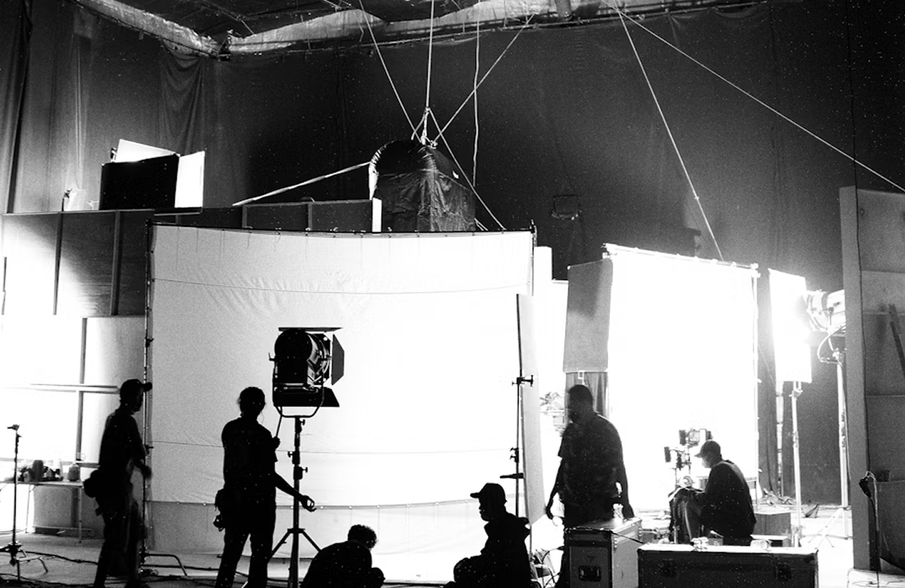 FX Productions Canada Silhouetted crew members work on a film set with large screens, lighting equipment, and rigging visible in the background. Toronto Video Production Company