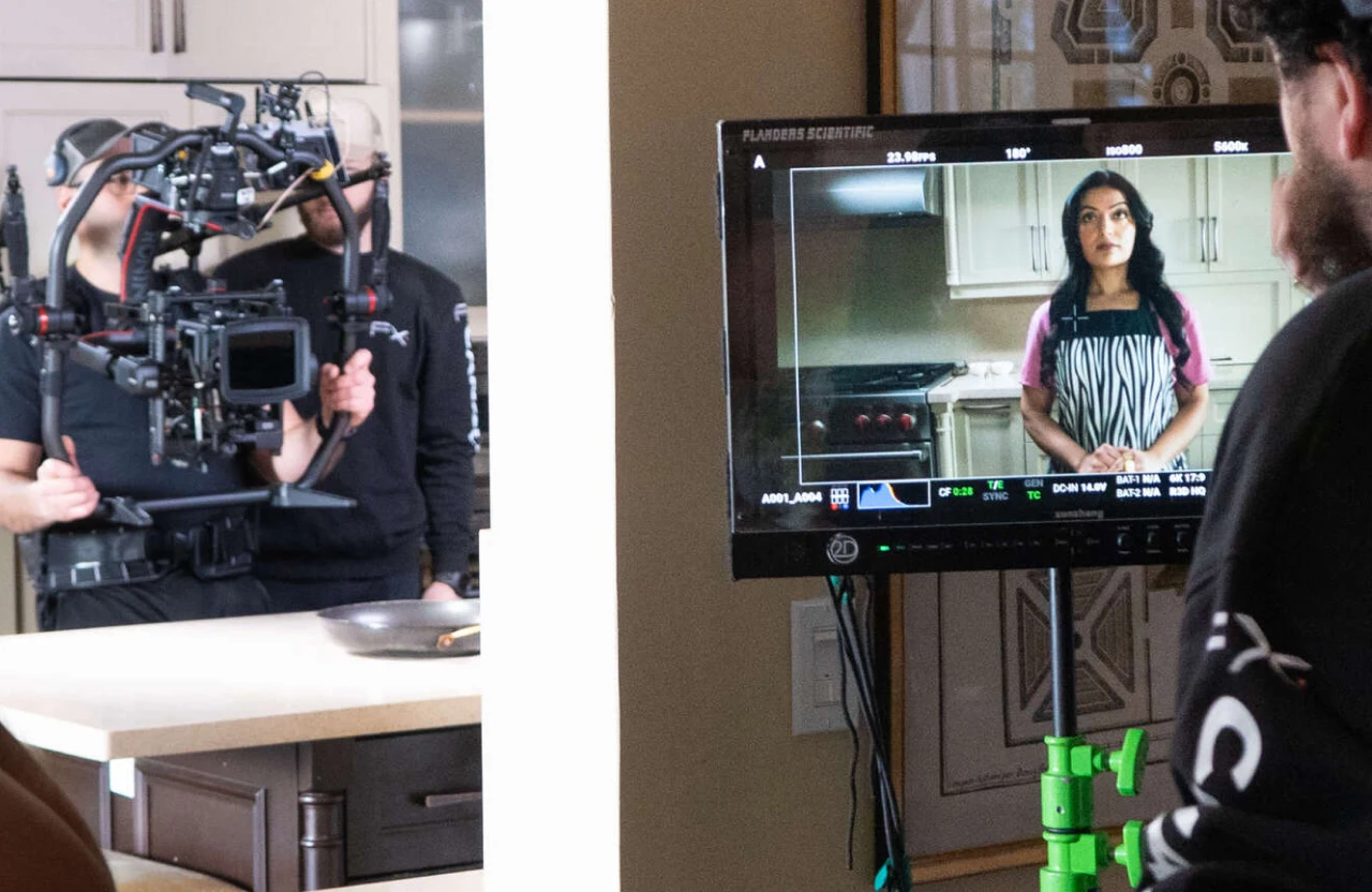 FX Productions Canada A film crew records a woman standing in a kitchen while her image appears on a monitor during a scalable corporate video production shoot. Toronto Video Production Company