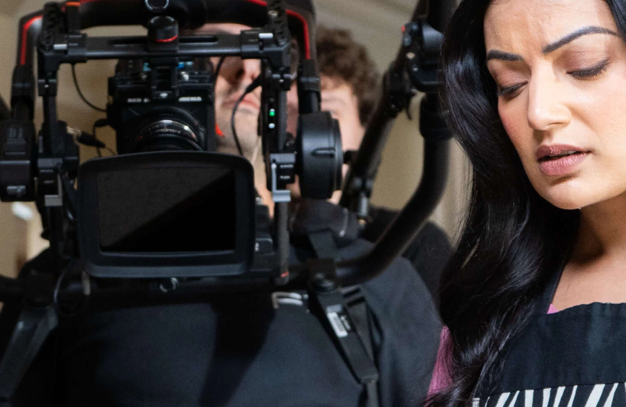 FX Productions Canada A camera operator from a full service video production company films a woman in an apron, who is looking down; the focus is on the filmmaking equipment and her concentrated expression. Toronto Video Production Company