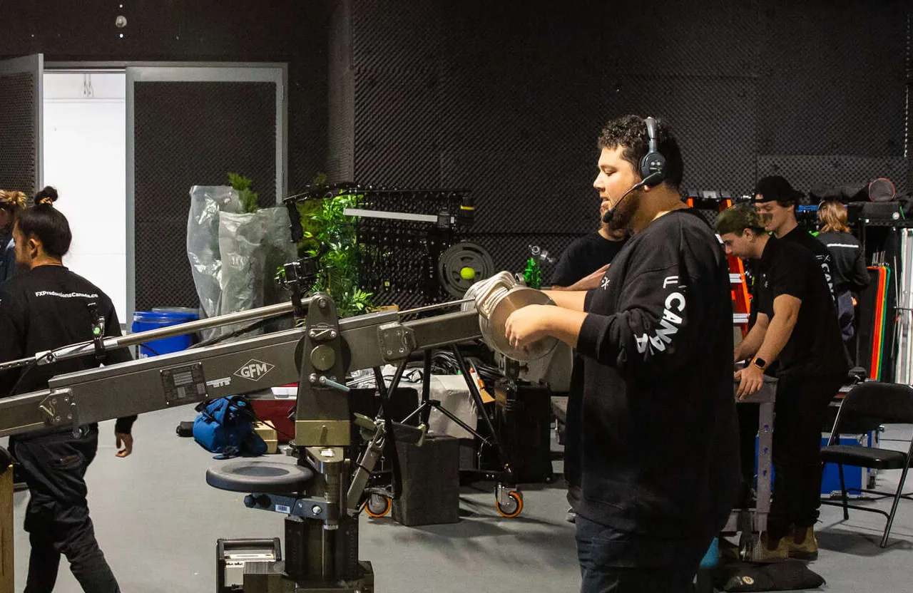 FX Productions Canada A crew member operates a camera crane while others work with equipment in a full service video production studio. Toronto Video Production Company