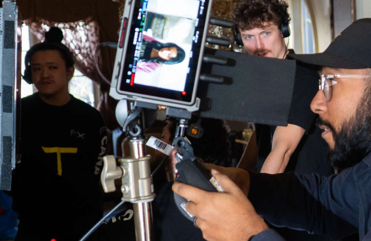 FX Productions Canada Three crew members operate a professional video camera setup indoors, filming an employer branding video in Toronto; a monitor displays a woman’s close-up while cables and equipment are visible. Toronto Video Production Company