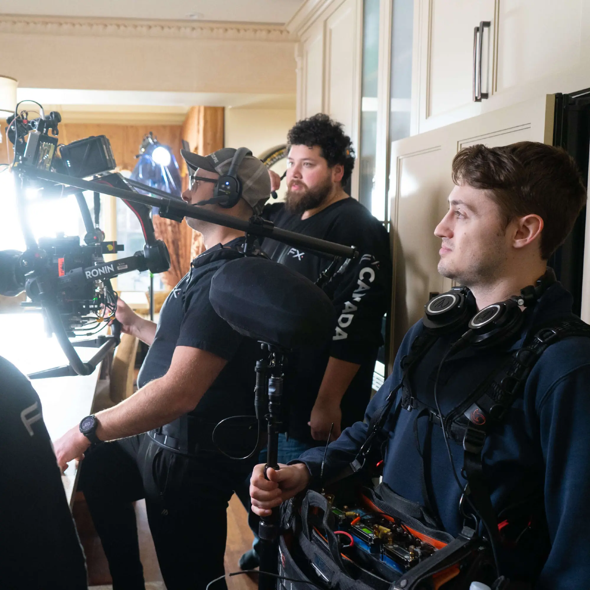 FX Productions Canada A film crew operates cameras and audio equipment indoors, focusing intently on a production set. Toronto Video Production Company