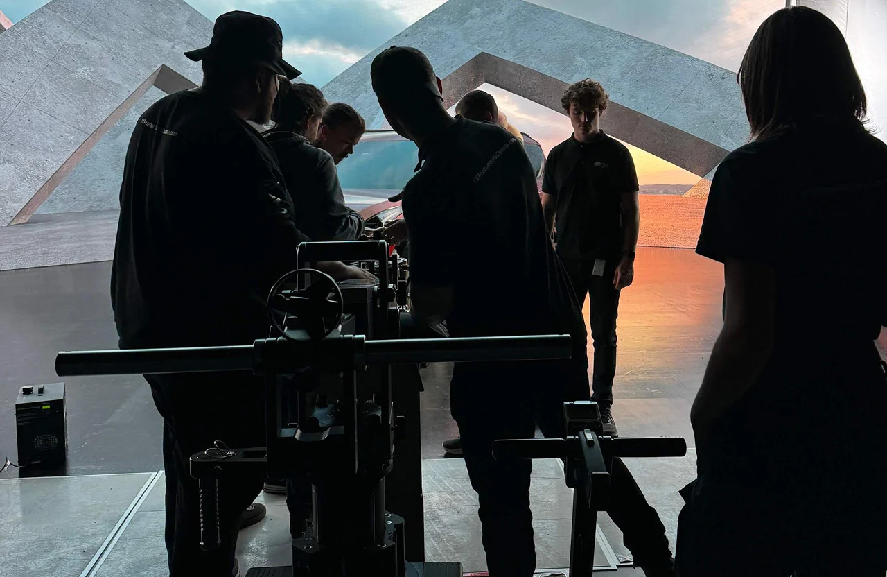 FX Productions Canada Several people stand around film equipment on a set with geometric structures and a sunset backdrop. Toronto Video Production Company
